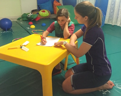 Child is writing during occupational therapy in Darwin